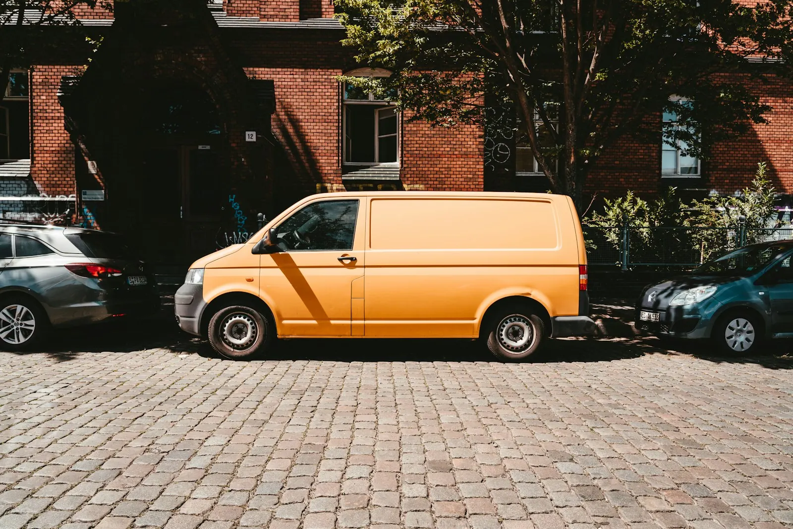 A yellow work van parked on a street