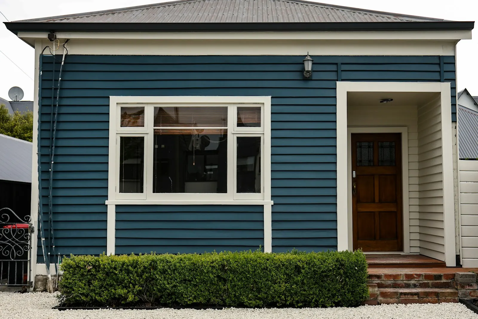A blue weatherboard house with white window trim