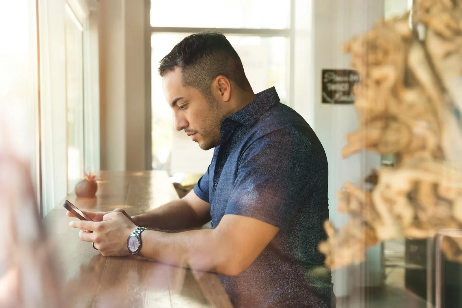 A man at a table checking his phone